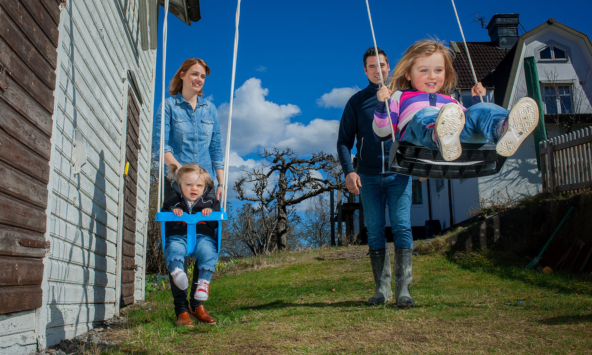 Frida och hennes familj gungar i trädgården